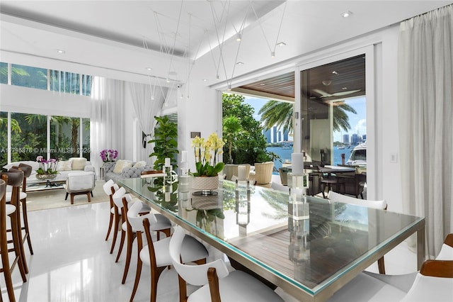 dining room featuring a water view and a healthy amount of sunlight
