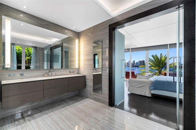 ensuite bathroom with double vanity, a walk in shower, and ensuite bathroom