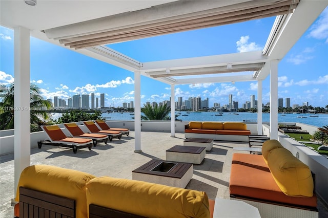 view of patio / terrace featuring a city view, a water view, and an outdoor living space