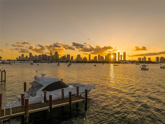 view of dock featuring a water view and a view of city