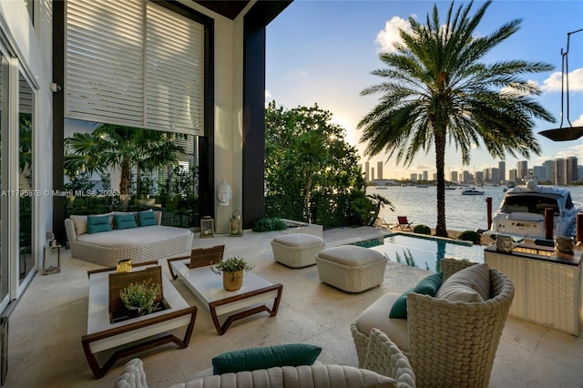 view of patio / terrace featuring a water view, a view of city, and an outdoor pool
