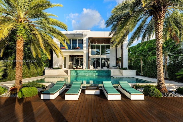 rear view of house with an outdoor hangout area, stucco siding, an outdoor pool, and a balcony