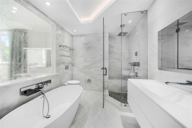 bathroom with a stall shower, marble finish floor, recessed lighting, and a freestanding tub