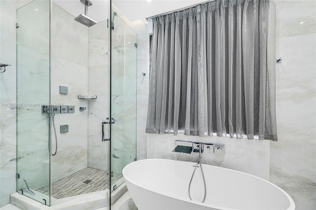 full bath featuring a shower stall and a freestanding tub