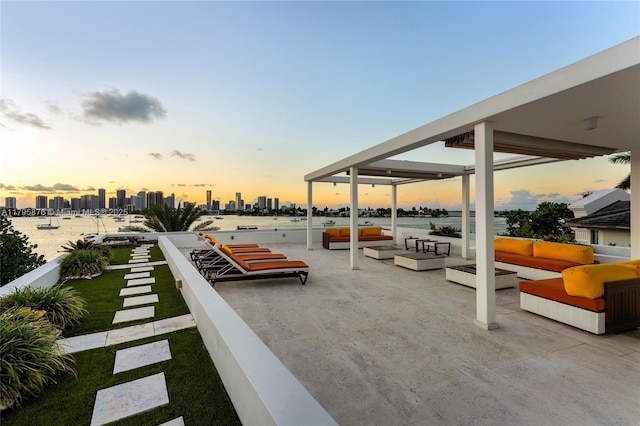 patio terrace at dusk featuring a view of city and outdoor lounge area