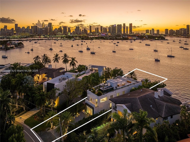 aerial view at dusk with a water view and a view of city