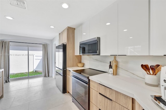 kitchen featuring visible vents, modern cabinets, light countertops, stainless steel appliances, and recessed lighting