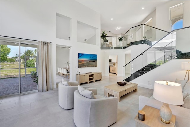 living room featuring recessed lighting, high vaulted ceiling, a ceiling fan, and stairs