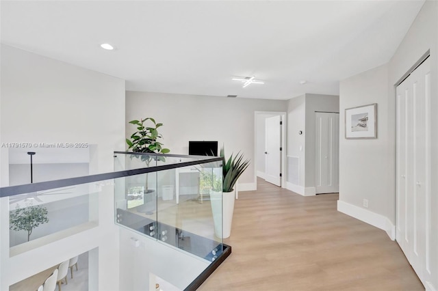 hall with light wood-style floors, recessed lighting, baseboards, and visible vents