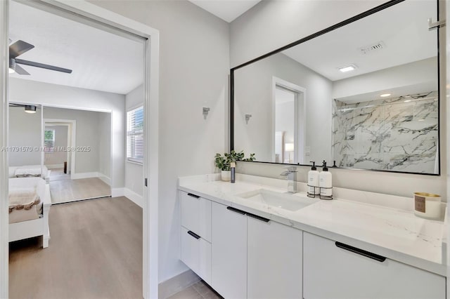 ensuite bathroom with wood finished floors, baseboards, ceiling fan, a marble finish shower, and ensuite bath