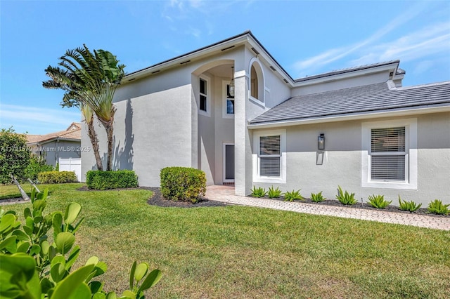 view of front of home with stucco siding and a front yard