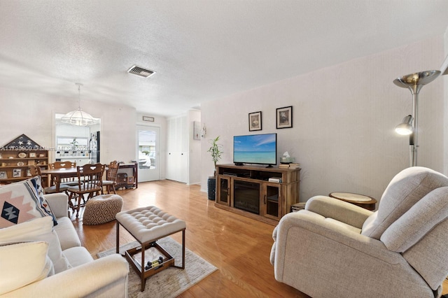 2935 W Crosley Dr Unit B, West Palm Beach, FL 33415 - living area featuring wood finished floors, a textured ceiling, and a chandelier