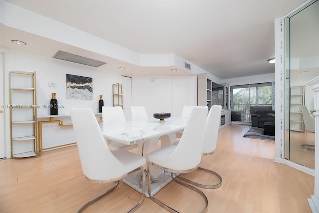 dining area featuring visible vents and light wood-style flooring