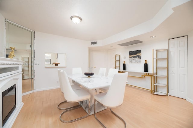 dining space with visible vents, light wood-style flooring, and baseboards