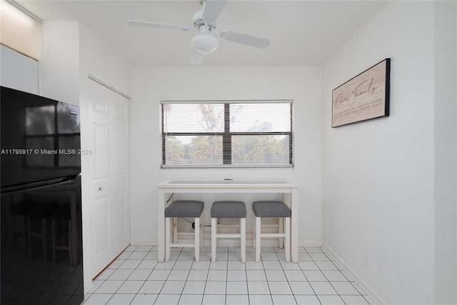 dining room with a ceiling fan, baseboards, and light tile patterned floors