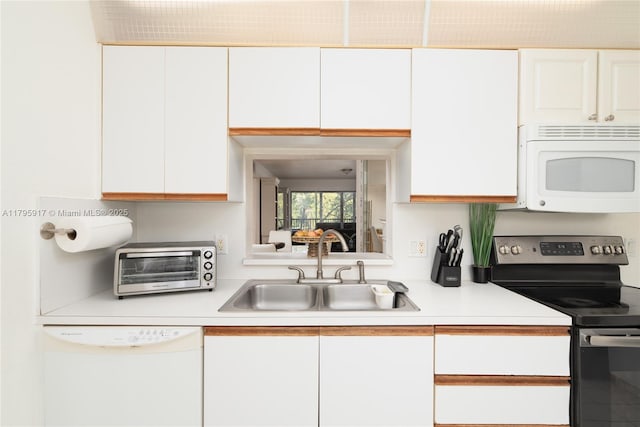 kitchen featuring a sink, light countertops, white cabinets, a toaster, and white appliances