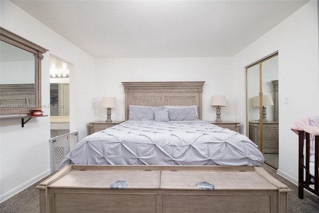 carpeted bedroom featuring baseboards and ensuite bath