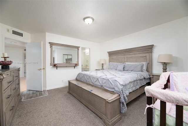 bedroom with baseboards, carpet, ensuite bath, and visible vents