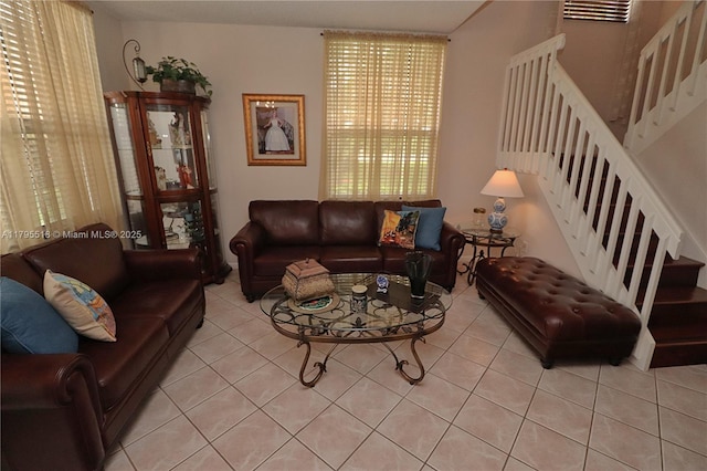 living room featuring light tile patterned floors and stairs