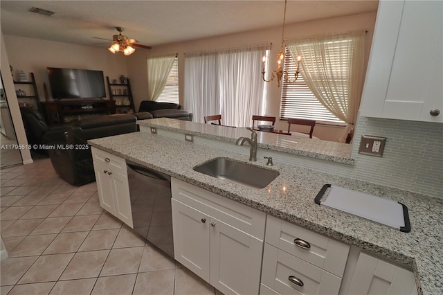 kitchen featuring a sink, dishwasher, white cabinetry, light tile patterned floors, and visible vents