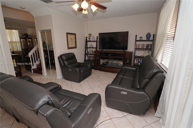 living room with a ceiling fan, visible vents, and light tile patterned floors