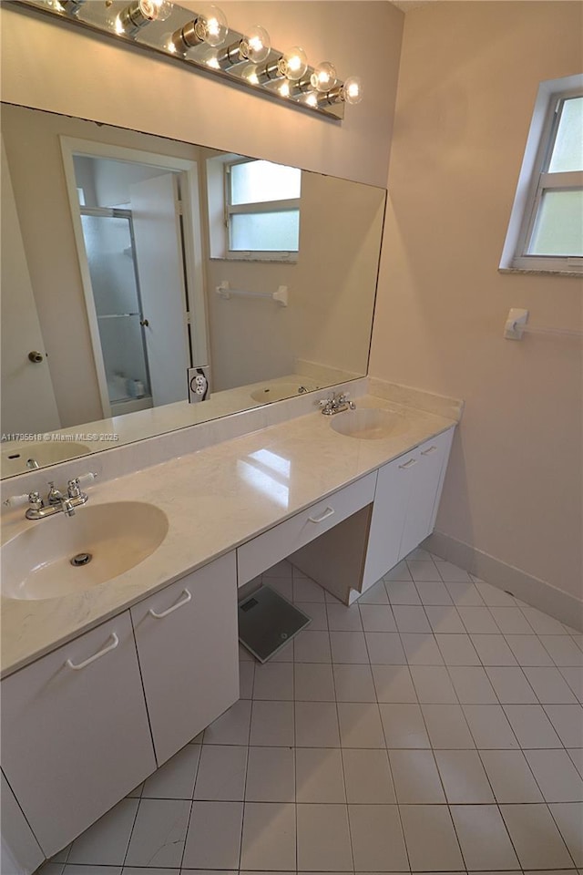 full bathroom featuring double vanity, a sink, an enclosed shower, and a wealth of natural light