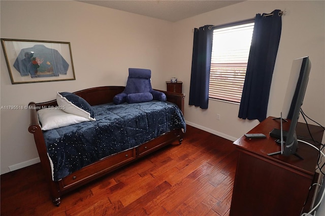 bedroom featuring baseboards and wood finished floors