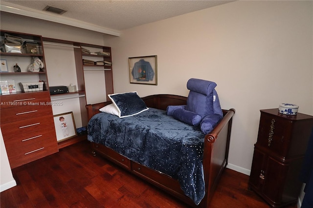 bedroom featuring visible vents, a textured ceiling, and wood finished floors
