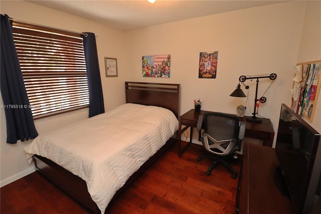 bedroom featuring baseboards and wood finished floors