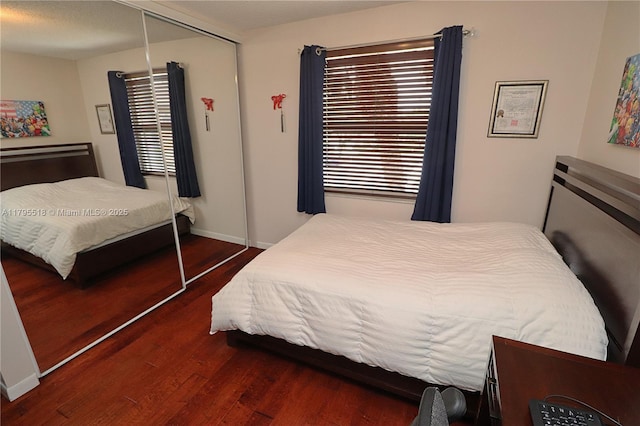 bedroom featuring multiple windows, a closet, and wood finished floors