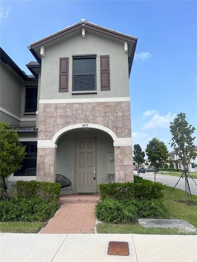 exterior space featuring stucco siding and stone siding