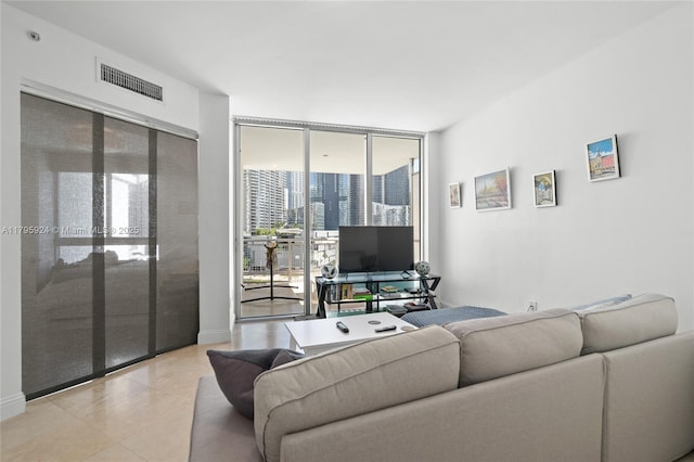 living room featuring light tile patterned floors, floor to ceiling windows, and visible vents