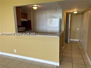 interior space with light tile patterned floors and baseboards