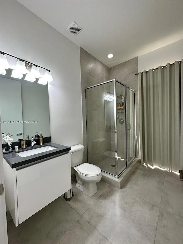 full bath featuring vanity, a shower stall, toilet, and visible vents