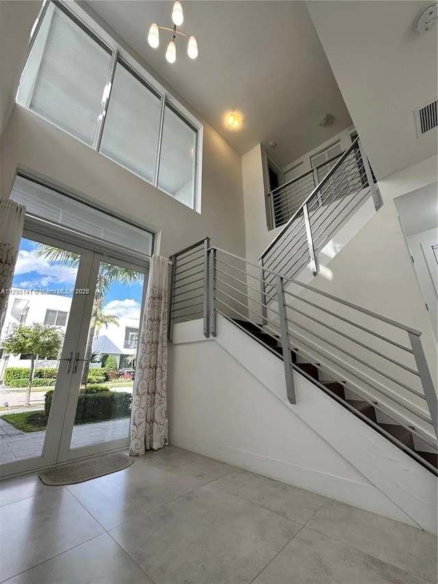 entrance foyer with visible vents, tile patterned floors, stairway, and french doors