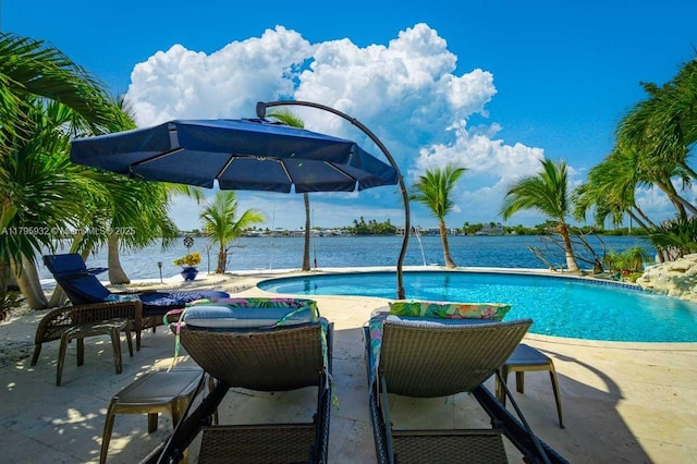 outdoor pool featuring a water view and a patio area