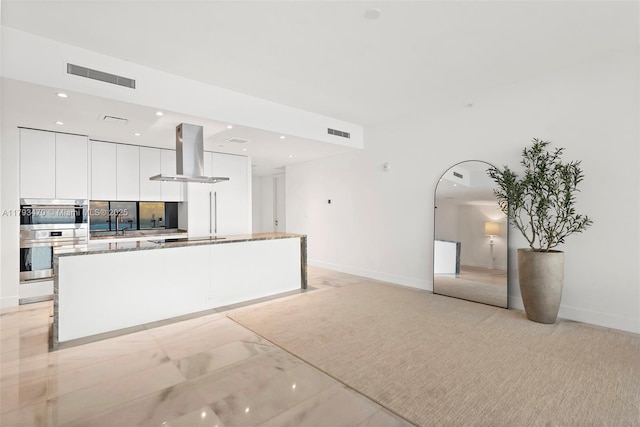 kitchen with island exhaust hood, visible vents, modern cabinets, white cabinets, and double oven