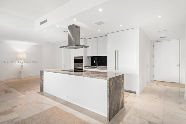 kitchen with island range hood, modern cabinets, white cabinets, marble finish floor, and recessed lighting