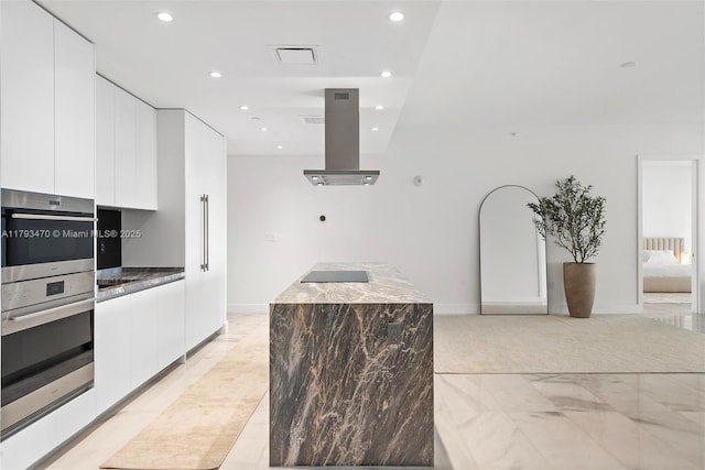 kitchen featuring modern cabinets, island range hood, recessed lighting, a center island, and white cabinets