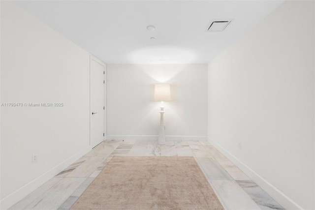 unfurnished room featuring baseboards, visible vents, and marble finish floor