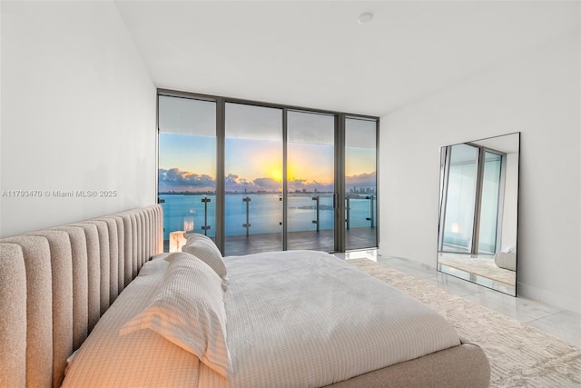 bedroom with floor to ceiling windows and access to exterior