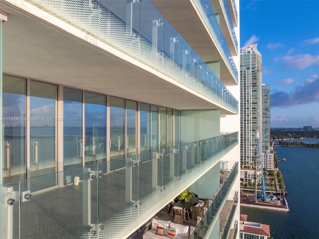 balcony with a water view and a view of city