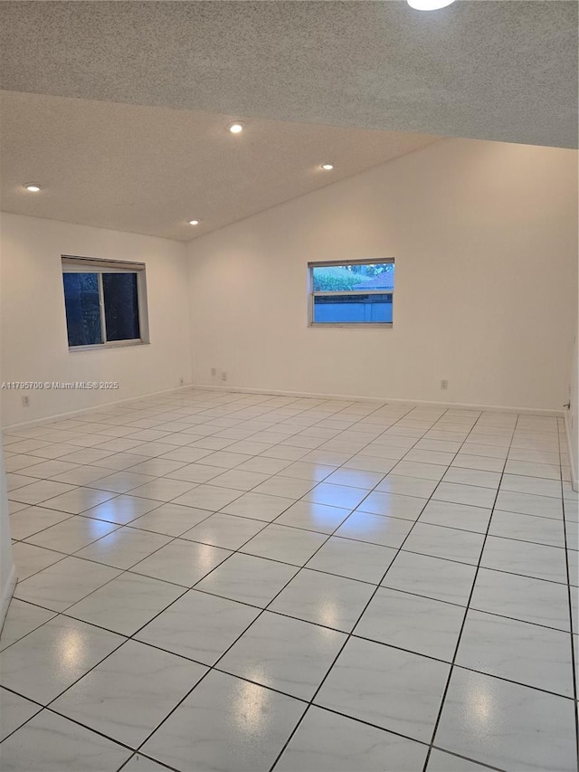 unfurnished room featuring recessed lighting, a textured ceiling, light tile patterned floors, and lofted ceiling