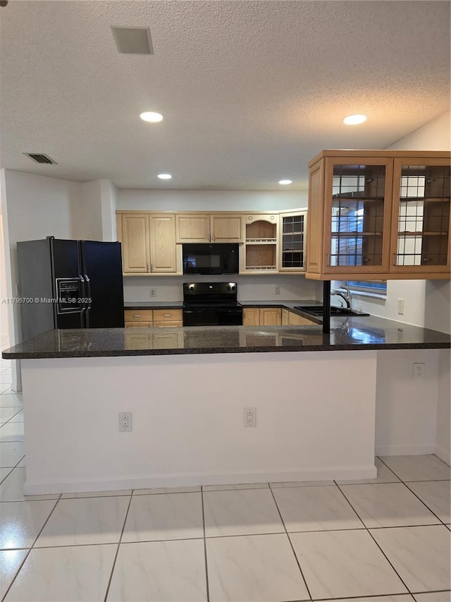 kitchen with dark stone counters, a textured ceiling, black appliances, and glass insert cabinets