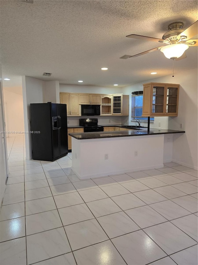 kitchen featuring a peninsula, dark countertops, glass insert cabinets, a textured ceiling, and black appliances
