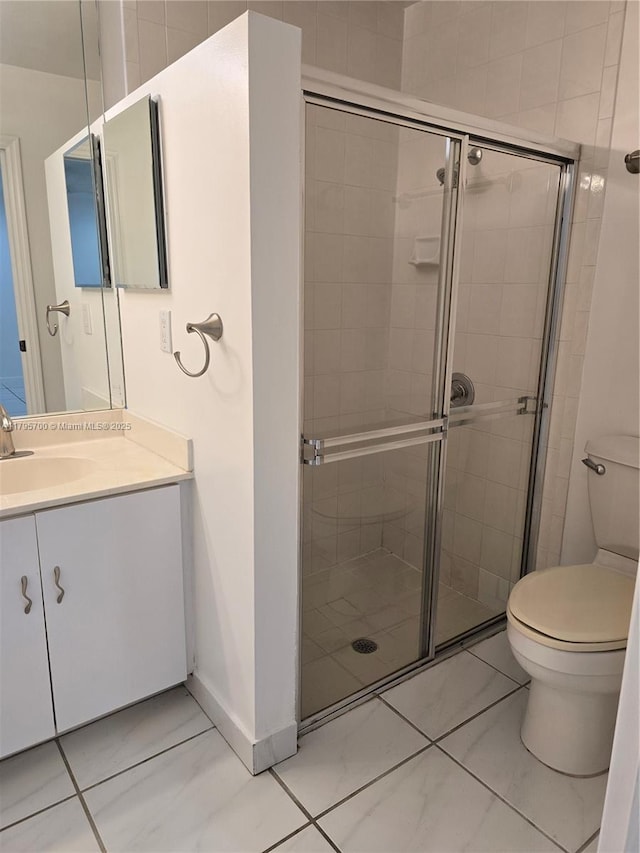 full bathroom featuring vanity, toilet, baseboards, and a stall shower