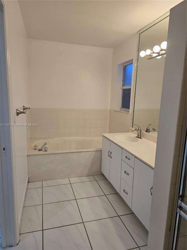 bathroom featuring vanity, tile patterned floors, and a bath
