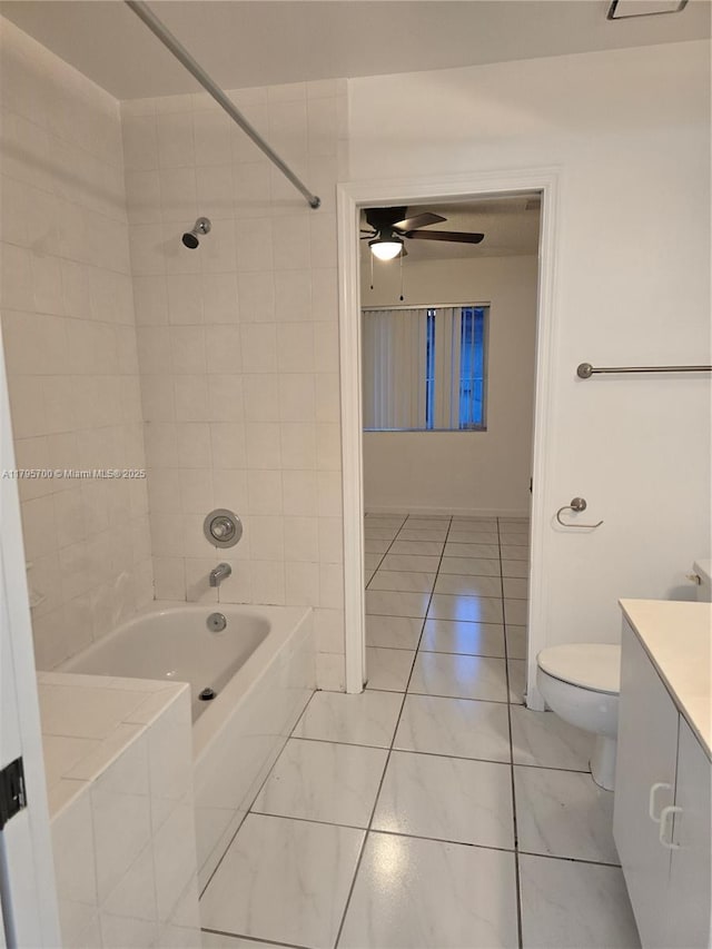 bathroom with ceiling fan, tile patterned flooring, shower / washtub combination, vanity, and toilet