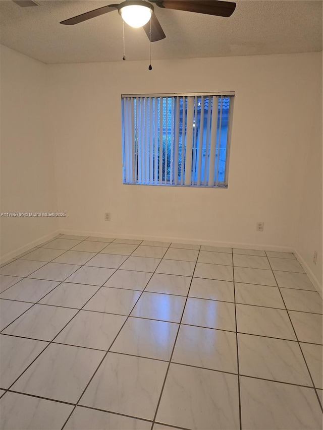 spare room featuring a ceiling fan, a textured ceiling, and light tile patterned flooring