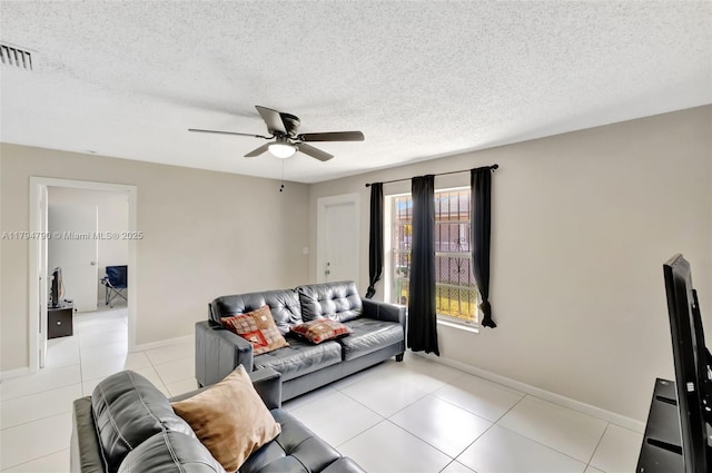 tiled living area featuring baseboards, ceiling fan, a textured ceiling, and visible vents